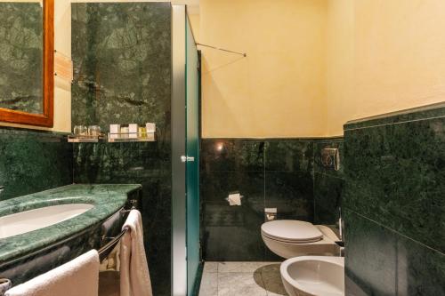 a bathroom with a toilet and a sink and a tub at Art Hotel Commercianti in Bologna