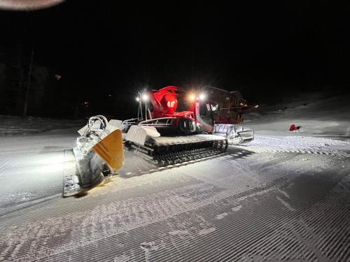 a bulldozer is working in the snow at night at Les appartements de Makalu Val Thorens in Val Thorens