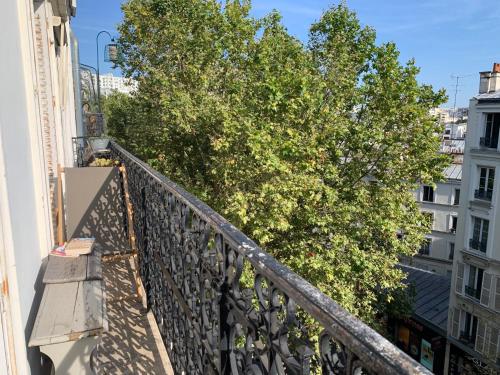 - un balcon avec un arbre sur le côté du bâtiment dans l'établissement Appart 54m2 quartier Jourdain 75020 etage 5 sans ascenseur, à Paris