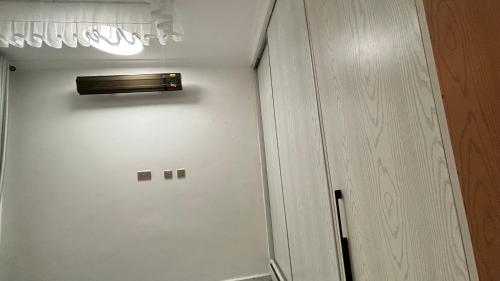 a white closet with a door next to a cabinet at Classic residence juja in Kalimoni