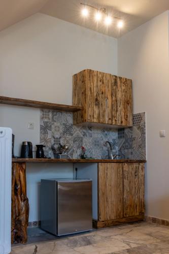 a kitchen with wooden cabinets and a stainless steel refrigerator at 1924 Studios 4 in Áyios Pétros