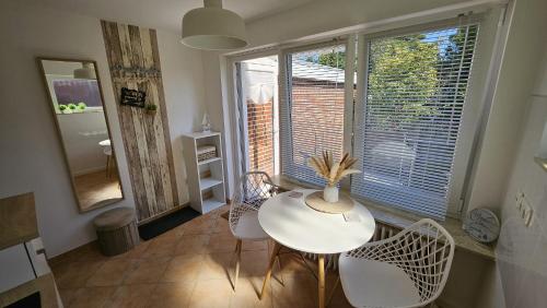 a white table and chairs in a room with a window at Lust auf Meer - Ferienappartement in Cuxhaven
