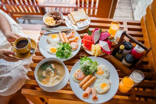 een tafel met borden eten en een persoon met een kopje koffie bij Salakphet Resort in Ko Chang