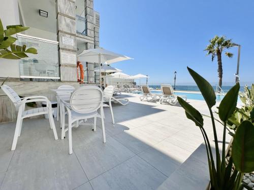 a patio with a table and chairs and the ocean at Hotel Apartamentos Marina Luz in Chipiona
