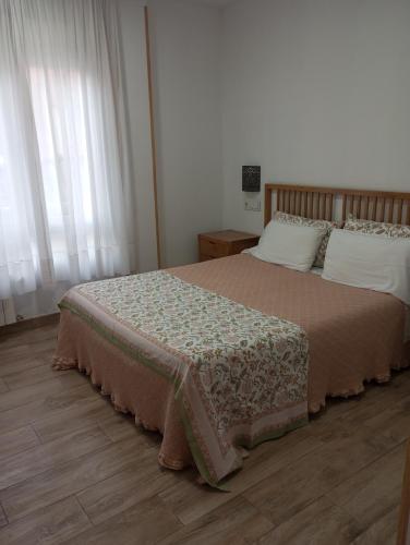 a bedroom with a bed with a brown blanket and white pillows at Hospedaje Magallanes in Santander
