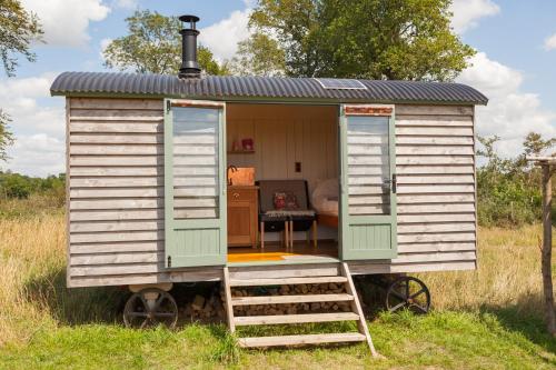 a tiny house on wheels in a field at Daisy Shepherds Hut in Kent