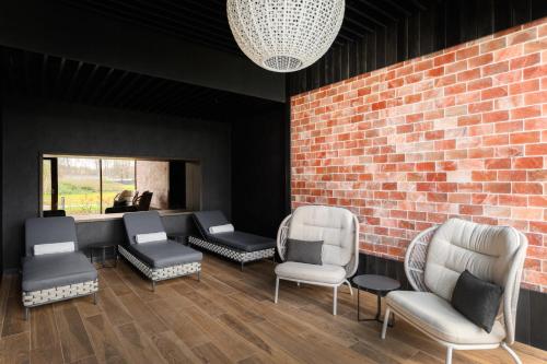 a waiting room with chairs and a brick wall at Melea - The Health Concept - Adults Only Hotel in Sárvár