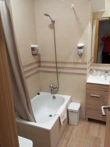 a bathroom with a tub and a toilet and a sink at Hospedaje Magallanes in Santander