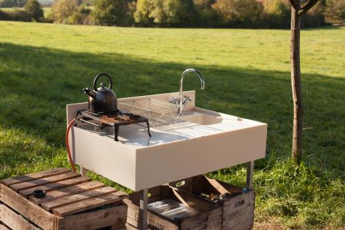 a white sink with a tea kettle sitting on top at Oak Yurt in Kent