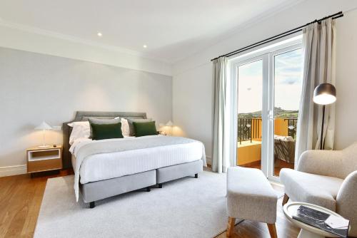 a bedroom with a bed and a large window at Dolce CampoReal Lisboa in Turcifal