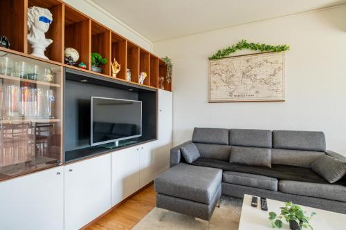 un salon avec un canapé et une télévision dans l'établissement Chez Virgil - Terrasse vue dégagée, parking privé, à Ernolsheim-Bruche