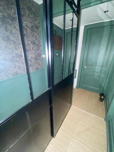 a hallway with glass walls and a door at Une Ferme en Ville in Bron