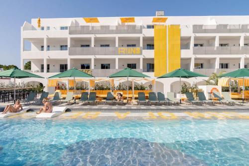 a swimming pool with a hotel in the background at Ryans Lolas - Adults Only in San Antonio Bay