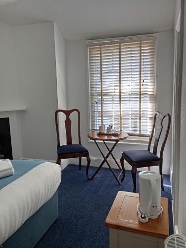 a bedroom with a bed and two chairs and a table at Royal Ocean Racing Club in West Cowes