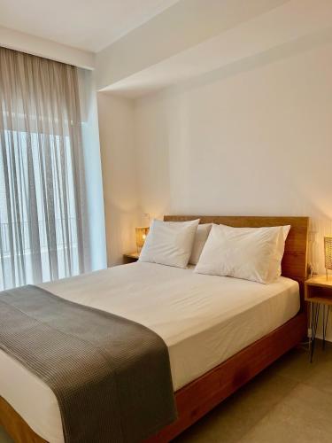 a bedroom with a large bed with a large window at White luxury apartment in Tríkala