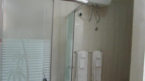 a bathroom with a shower and a mirror and towels at Bojo Beach Resort in Bortianor