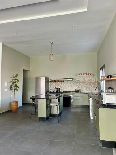 a large kitchen with a table and chairs in it at Villa Karama Essaouira Getaway in Bou Mkila