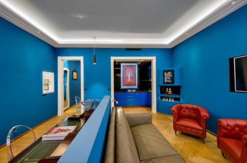 a living room with blue walls and a couch at Art Hotel Commercianti in Bologna