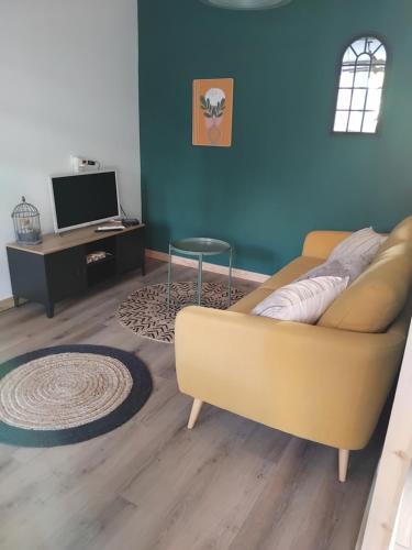 a living room with a couch and a table at La grange aux animaux in Tollevast