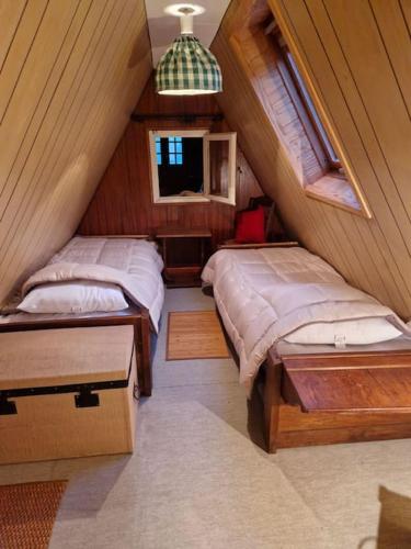 - une chambre mansardée avec 2 lits et une fenêtre dans l'établissement Chalet à la Montagne, à Sainte-Marie-de-Campan