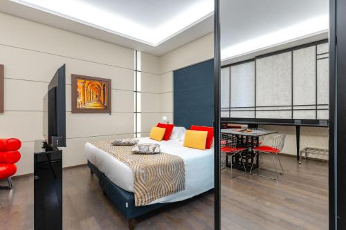 a bedroom with a bed and a table and chairs at Art Hotel Commercianti in Bologna