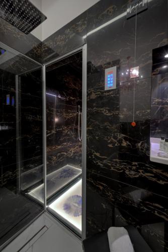 a shower in a room with black tiles at Art Hotel Commercianti in Bologna