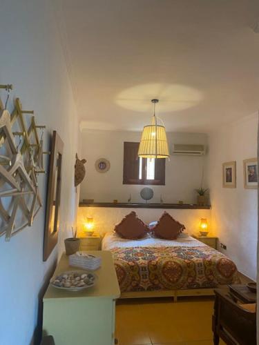 1 dormitorio con cama, mesa y luz en La Casa Palmera - Caminito Del Rey, en Pizarra