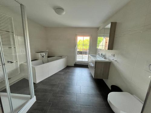a bathroom with a tub and a toilet and a sink at Ferienwohnungen Hopfenhaus in Spalt