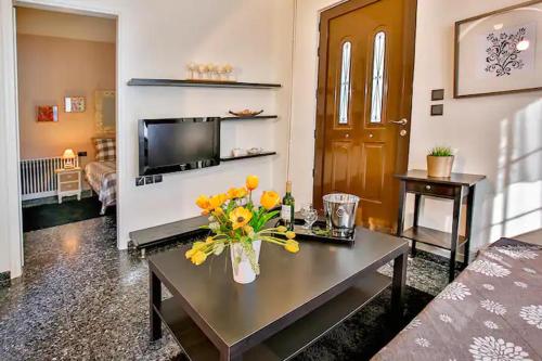 a living room with a table with flowers on it at Cozy near the sea-Sunset View Apartments in Ixia