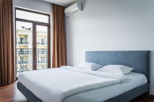 a bedroom with a large bed with a large window at Boulevard 115 in Tashkent