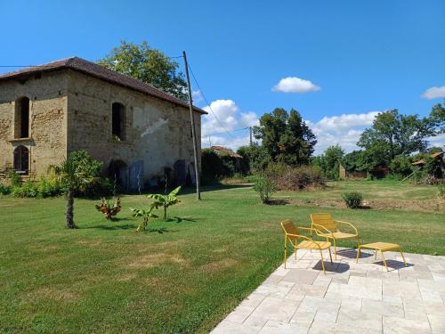 two chairs and a table in front of a building at Chateau in sw France - Comfortable 6 Bedroom House in Sariac-Magnoac