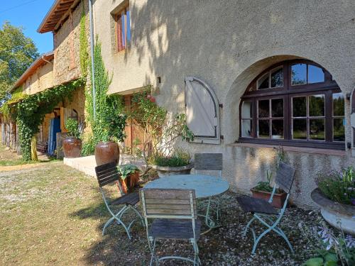 a table and chairs in front of a building at Chateau in sw France - Comfortable 6 Bedroom House in Sariac-Magnoac