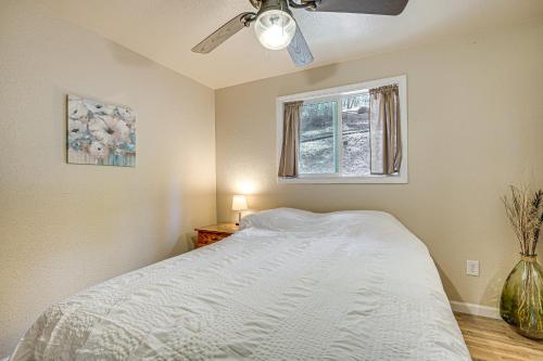 a bedroom with a bed with a ceiling fan and a window at Mtn-View Gem Deck, Grill and Fire Pit in West Point in Volcano