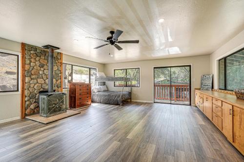 a living room with a ceiling fan and a fireplace at Mtn-View Gem Deck, Grill and Fire Pit in West Point in Volcano