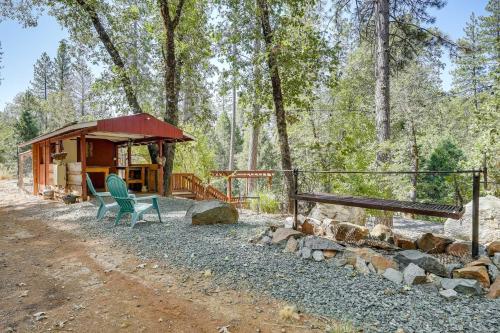 a cabin in the woods with a bench and chairs at Mtn-View Gem Deck, Grill and Fire Pit in West Point in Volcano
