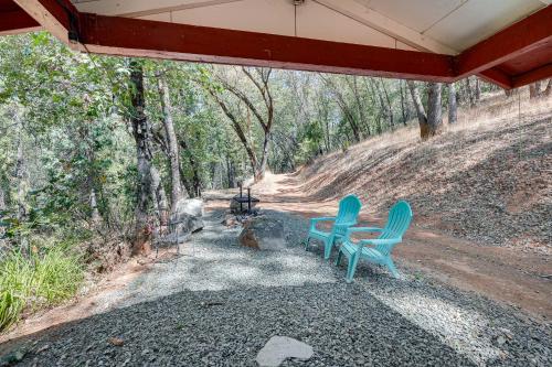 two blue chairs sitting under a shed in the woods at Mtn-View Gem Deck, Grill and Fire Pit in West Point in Volcano