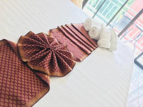 a group of towels and towels on a bed at Global Hotel Beach View in Patong Beach