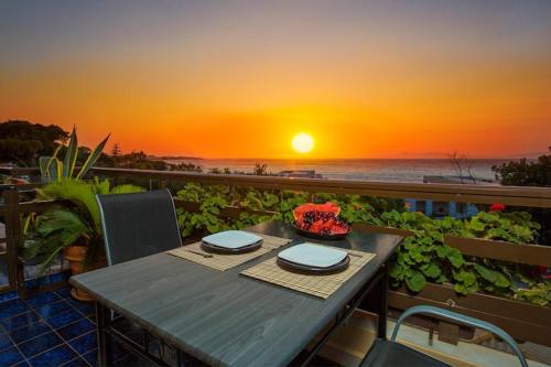 Una mesa en un balcón con vista al mar. en Sea View-Sunset View Apartments, en Ixia