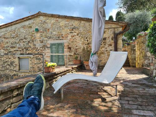 a person with their feet up on a chair and an umbrella at La Terrazza, Cetona, Toscana in Cetona