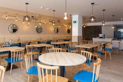 ein Restaurant mit Holztischen und blauen Stühlen in der Unterkunft R2 Bahia Kontiki in Puerto del Carmen