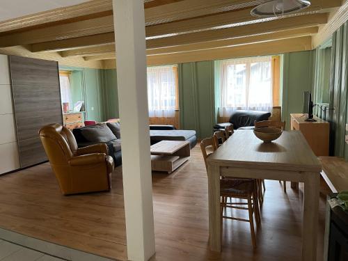 a living room with a couch and a table at Historische Maisonette-Wohnung mit Gästekarte und Ermässigungen in Naters