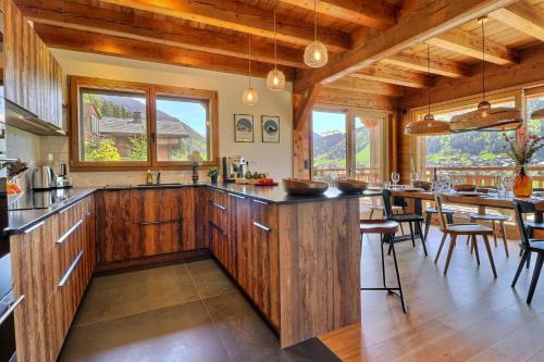 une cuisine avec des placards en bois et un grand îlot dans l'établissement Chalet Alpaga, à Montriond