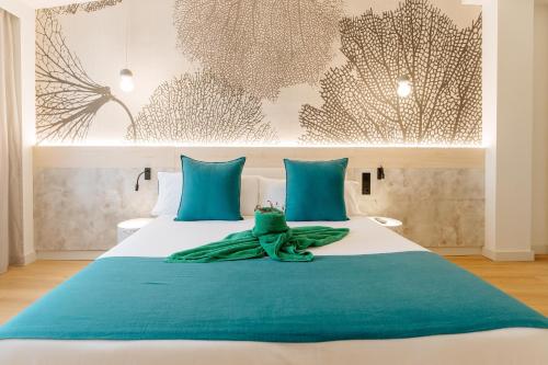 a bedroom with a large bed with blue pillows at R2 HIGOS BEACH in Costa Calma