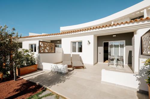 a patio of a home with white furniture at R2 HIGOS BEACH in Costa Calma