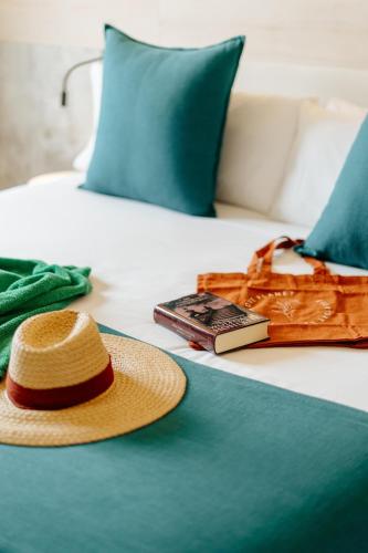 a straw hat and a cell phone on a bed at R2 HIGOS BEACH in Costa Calma