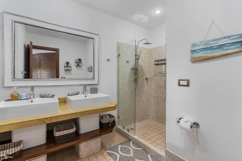 タマリンドにあるNax3 Luxury Condo in Upscale Langosta Communityの洗面台2つとシャワー付きのバスルーム