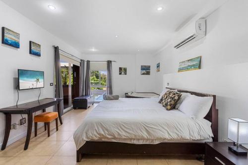 タマリンドにあるNax3 Luxury Condo in Upscale Langosta Communityのベッドと机が置かれた寝室