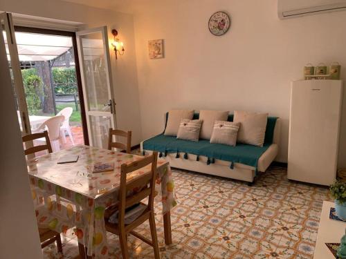 a living room with a couch and a table at Chalet Felicita con giardino Immerso nel bosco in Castellaneta Marina 