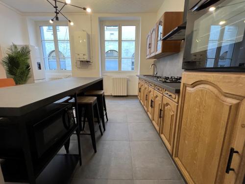 une cuisine avec des placards en bois et un grand comptoir dans l'établissement Appartement Deluxe - Jean Jaurès, à Saint-Étienne