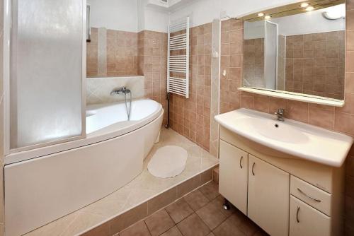 a bathroom with a white tub and a sink at Priestranný, svetlý apartmán in Podtureň